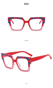 Detail view of red square glasses frames with blue diagonal stripes on top corners