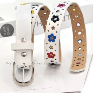 Detail of white leather belt featuring multi-colored floral cutouts and silver metal buckle