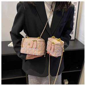 Dettaglio di piccole borse a secchiello in tweed rosa con trama e catena dorata