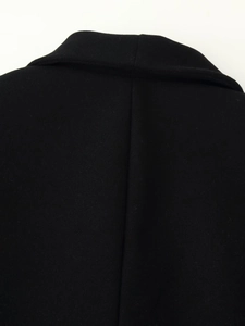 Close-up of the shawl collar and neat back seam on a black wool coat for women