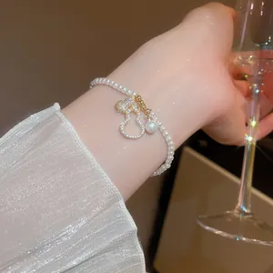 Détail du pendentif gourde dorée serti de zircons sur un bracelet en perles lustrées