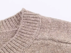 Detail of the crew neck collar and fine ribbed texture of this beige knitted cardigan