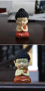Macro shot of cute Zen Buddha statue with joined palms in a peaceful praying posture