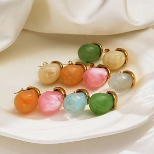 Colorful resin teardrop earrings with 18k gold plated stainless steel hoops on white plate
