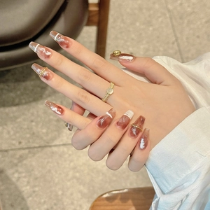 Caramel brown marble press-on nails in long coffin shape with golden 3D accents