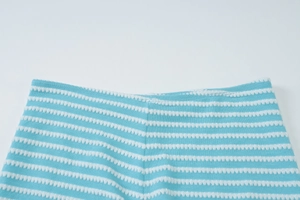 Close-up of blue and white striped knit fabric with elastic waistband detail