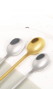 Macro detail of round spoon heads with gold and silver mirror-polished finish