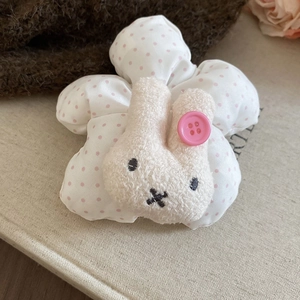 Close-up of a plush white rabbit with pink dots on a soft scrunchie hair accessory
