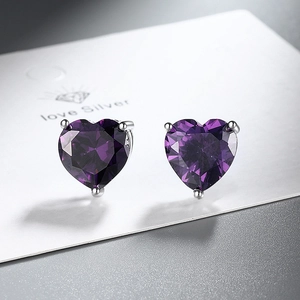 Macro shot of purple heart zircon earrings with silver three-prong setting and facets