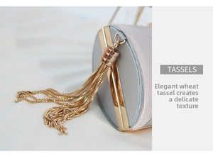 Detail showing the elegant golden fringe tassels and fine satin texture of the evening clutch