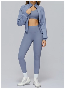 Detail eines blauen Yoga-Sets mit Stehkragenjacke mit Reißverschluss und hoher Leggings