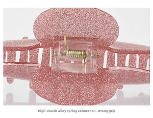 Macro shot of high-elastic alloy spring on pink glitter acrylic hair claw clip