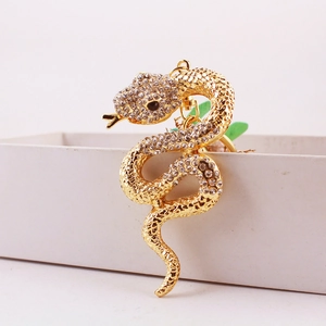 Creative golden snake keychain with sparkling rhinestones on a white gift box