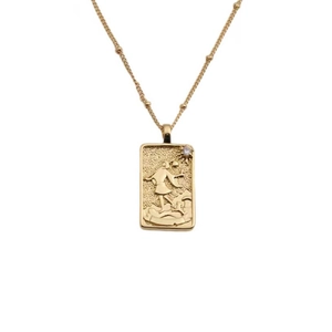 Détail macro du collier dieu du soleil plaqué or avec pendentif rectangulaire et chaîne fine