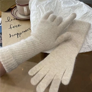 Knitted beige long rabbit fur gloves with ribbed cuffs in a lifestyle winter setting