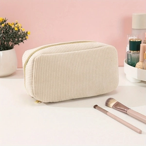 Detail of beige corduroy toiletry bag showing soft fabric texture and zipper closure