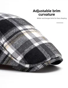 Detail of wide foldable brim on checkered ivy cap showing shape-correcting facial fit