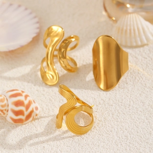 Three pieces set of golden irregular open rings with shells and sand background