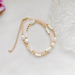 Detail of beaded necklace with Baroque pearls, pink crystals, and gold-plated steel clasp