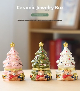 Ceramic Christmas tree jewelry boxes with bear reliefs and gold star toppers on a table