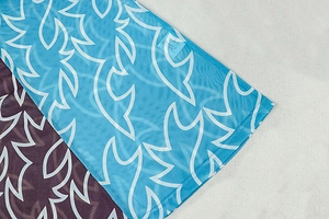 Gros plan du tissu en maille transparente avec motifs tribaux bleus et étiquette taille S
