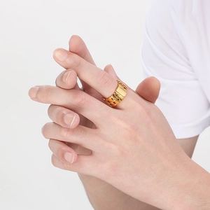 Macro detail of men's 18k gold plated Cuban link chain ring with embossed pattern