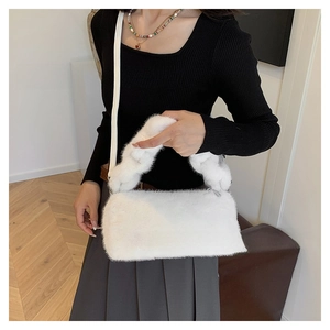 Close-up of soft white faux fur texture and dual-strap detail on this stylish handbag