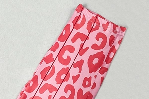 Gros plan sur un tissu léopard rose et rouge avec une texture en maille et des coutures