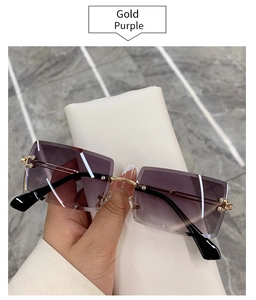Detail of rimless rectangle sunglasses with gold purple gradient lenses and gold bridge