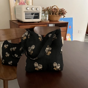 Macro detail of black texture fabric tote bag with vintage white rose jacquard patterns