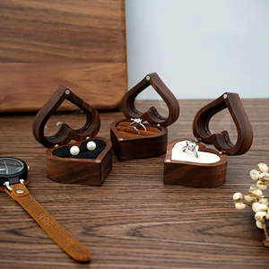 Detailed view of heart-shaped walnut ring boxes with velvet lining and jewelry