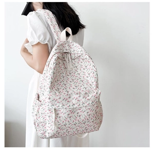 Floral canvas backpack with pink flower patterns shown on model from back view
