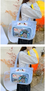 Detail of light blue plush penguin ita-bag showing clear window and soft texture
