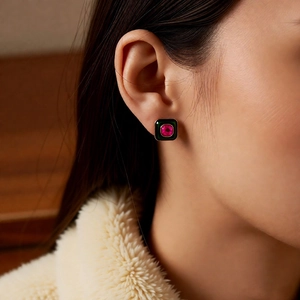 Close-up of vintage square emerald and ruby stud earring worn by a model