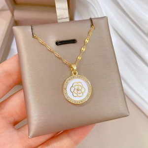 Detailed close-up of golden camellia pendant with micro-inlaid sparkling crystals