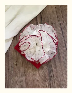 Détail d'un chouchou floral avec bordure en dentelle rouge et motif de fleurs douces