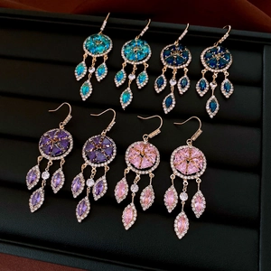 Detailed macro view of French style tassel earrings with colorful zircons in four vibrant hues