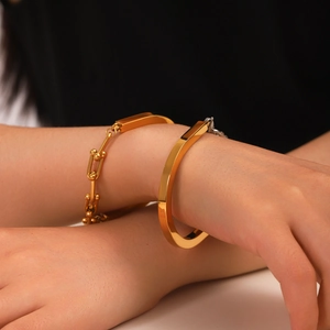 Vue détaillée du bracelet chaîne dorée avec boule et jonc fer à cheval lisse