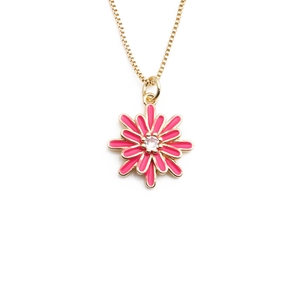 Detail of gold chain necklace with pink enamel daisy pendant and clear gemstone core