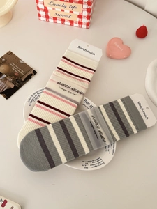 Close-up of striped cotton mid-calf socks set with vintage branding and gift packaging