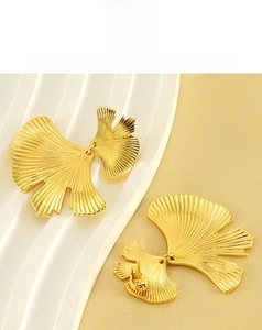 Detail of gold ginkgo leaf earrings featuring fine vein textures and layered design
