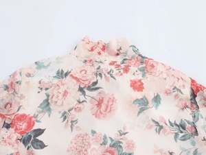 Detail of floral chiffon dress featuring a high collar and pink flower prints