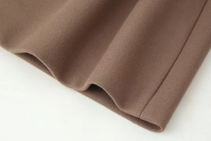 Detailed macro view of high-quality brown wool fabric texture and fine stitching on a coat