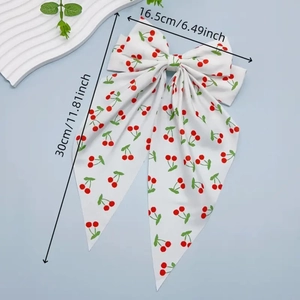Detail view of white cherry print bow hair clip with 16.5cm width and 30cm length dimensions