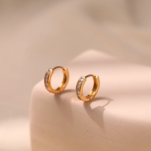 Detailed close-up of 18K gold-plated hoop earrings with sparkling cubic zirconia inlay