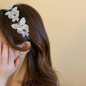 Detailed view of a silver butterfly headband on model showing elegant hairstyle fit