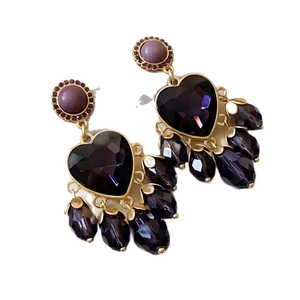 Vintage gold earrings featuring a large purple heart crystal and teardrop beads on white back