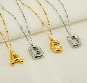 Detail of A B C D balloon initial necklaces in gold and silver finish with bead chains