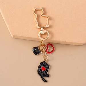Detail of creative cat keychain featuring a gold clasp with black cat and red heart charms