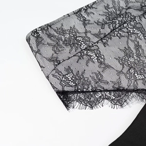 Gros plan sur la dentelle florale noire avec bordure cil délicate sur la robe